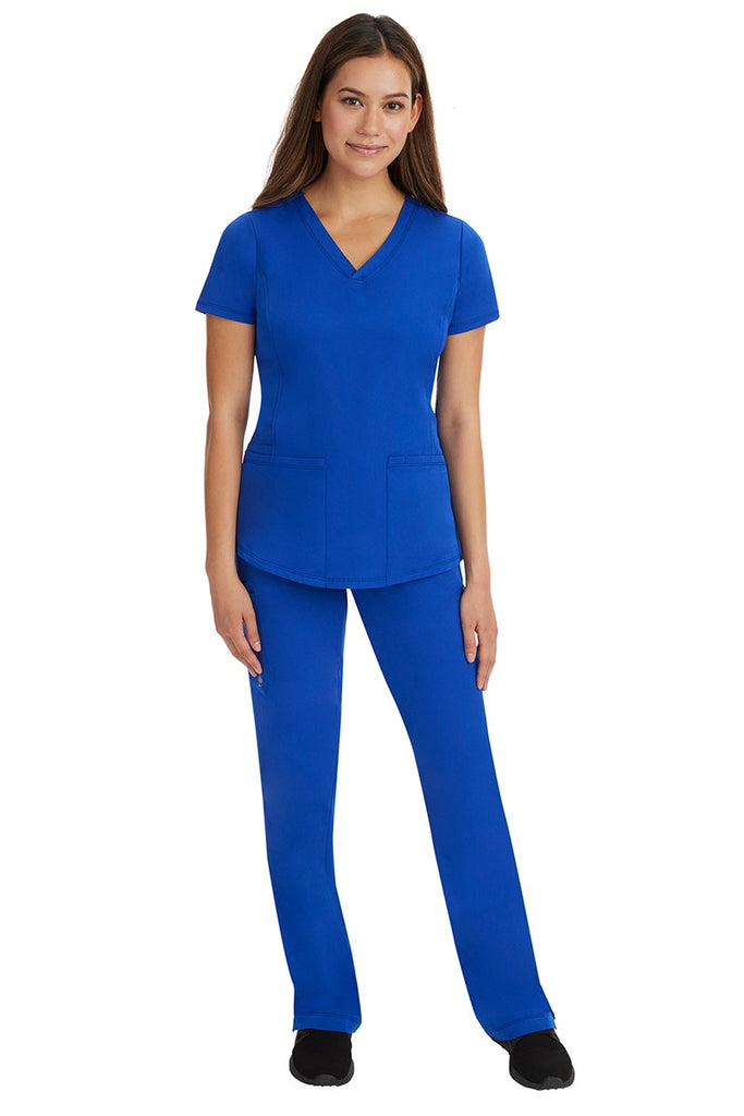 A young female nurse wearing a Women's Rebecca Multi-Pocket Drawstring Pant from HH Works in Galaxy Blue featuring a quick-dry, moisture wicking fabric that is fade resistant.
