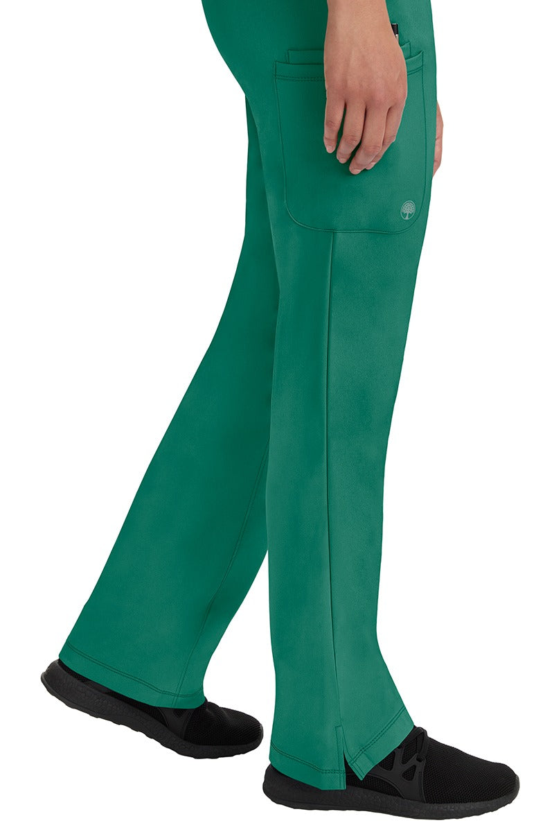 A young woman wearing an HH-Works Women's Rebecca Multi-Pocket Drawstring Pant in Hunter Green. Perfect for Healthcare Professionals working in Hospitals or as Physical Therapists, Optometrists, & Chiropractors!