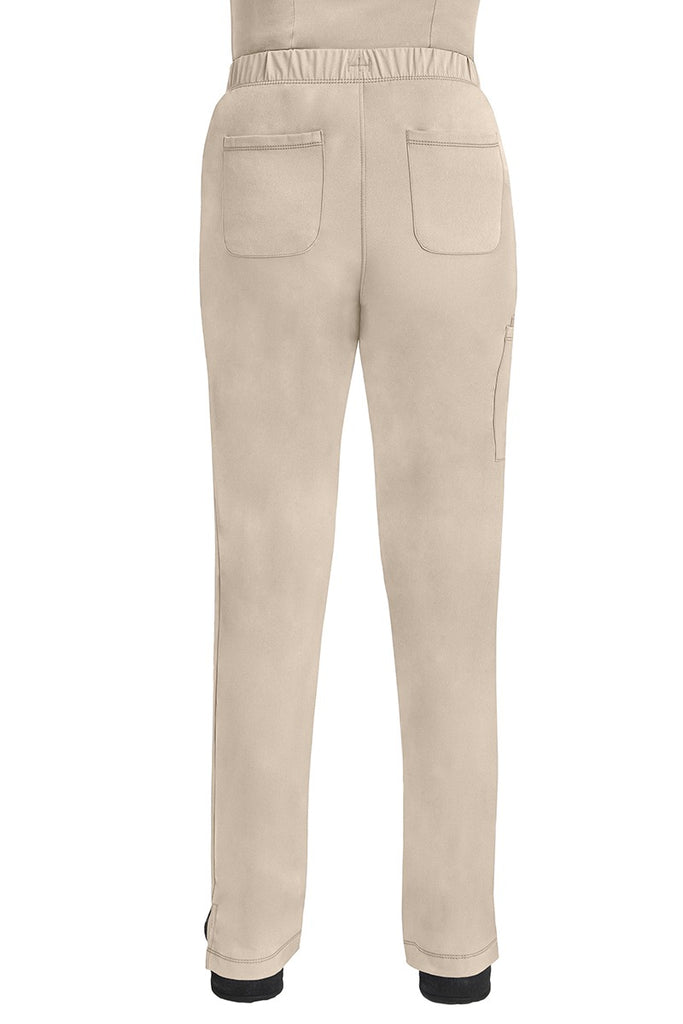 A lady CNA wearing an HH-Works Women's Rebecca Multi-Pocket Drawstring Pant in Khaki featuring 2 back patch pockets for any additional on the job storage needs.