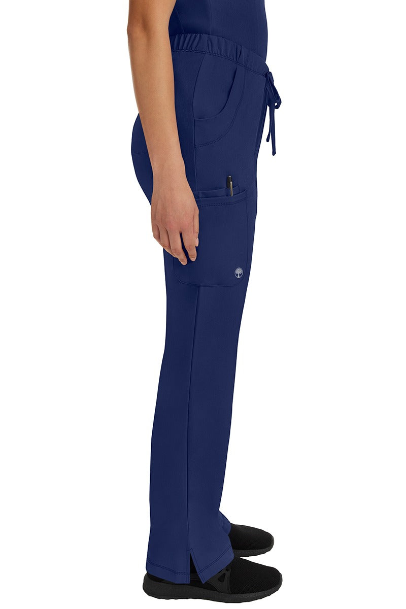 A young woman wearing an HH-Works Women's Rebecca Multi-Pocket Drawstring Pant in Navy featuring a super comfortable stretch fabric made of 91% polyester & 9% spandex.