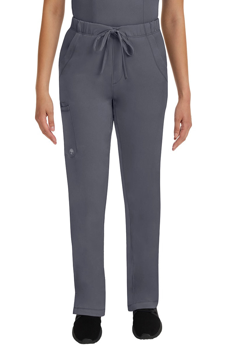 A young lady LPN wearing an HH Works Women's Rebecca Multi-Pocket Drawstring Pant in Pewter featuring n all elastic waistband with a drawstring tie front.