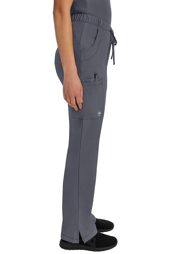 A young woman wearing an HH-Works Women's Rebecca Multi-Pocket Drawstring Pant in Pewter featuring a super comfortable stretch fabric made of 91% polyester & 9% spandex.