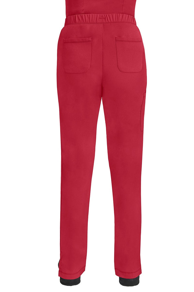 A lady CNA wearing an HH-Works Women's Rebecca Multi-Pocket Drawstring Pant in Red featuring 2 back patch pockets for any additional on the job storage needs.