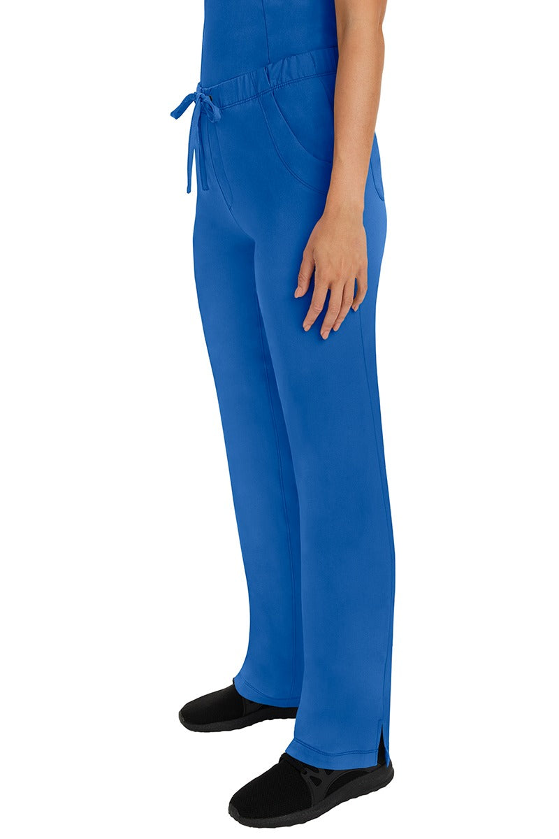 A woman Home Care Registered Nurse wearing a pair of HH-Works Women's Rebecca Multi-Pocket Drawstring Pants in Royal featuring side slits for additional range of motion.