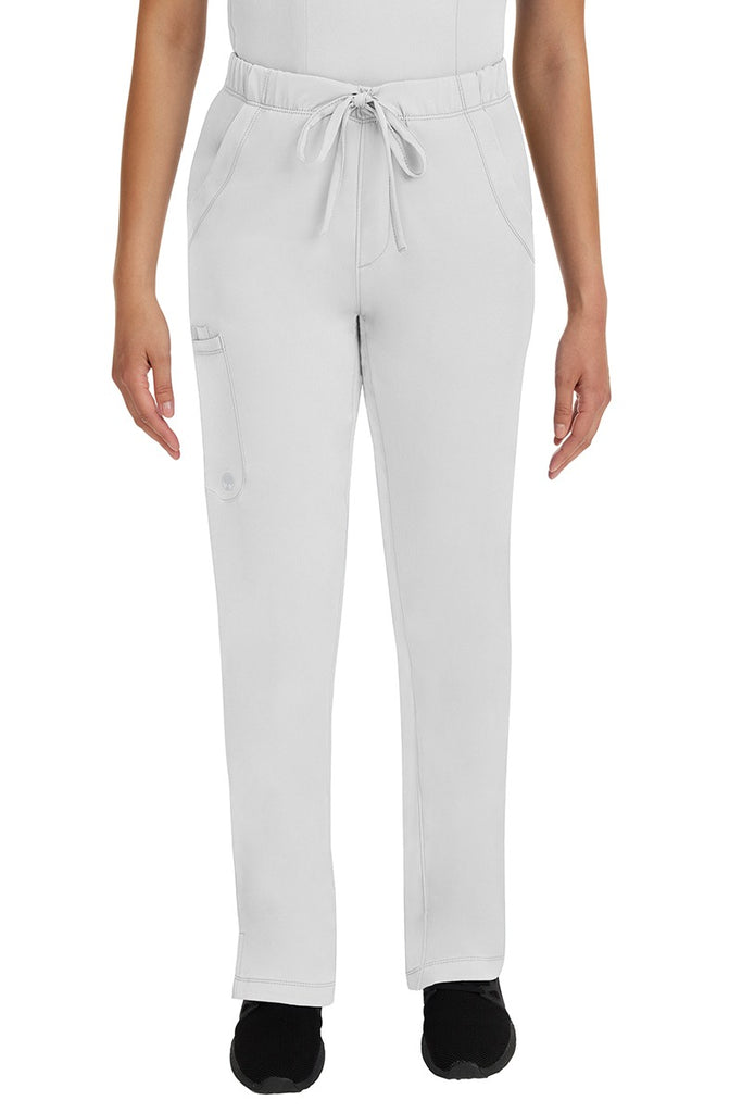 A young lady LPN wearing an HH Works Women's Rebecca Multi-Pocket Drawstring Pant in White featuring n all elastic waistband with a drawstring tie front.