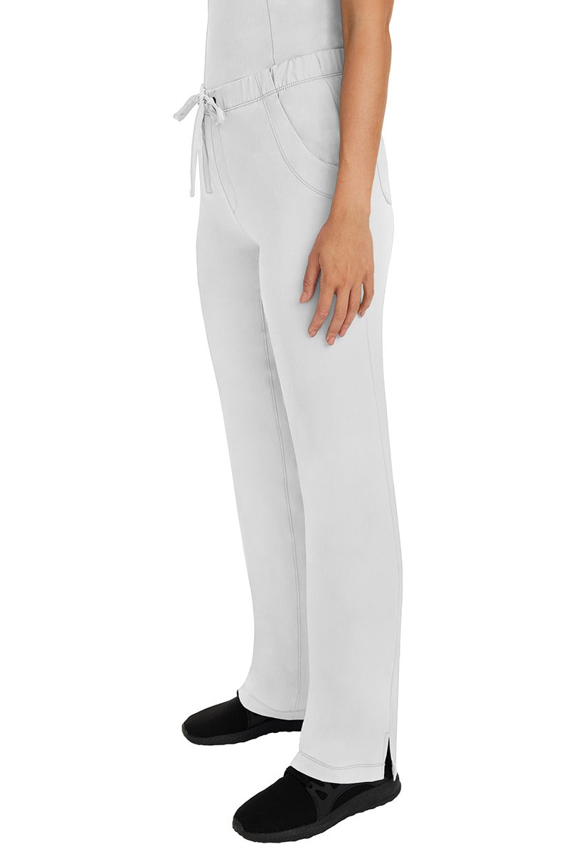 A woman Home Care Registered Nurse wearing a pair of HH-Works Women's Rebecca Multi-Pocket Drawstring Pants in White featuring side slits for additional range of motion.
