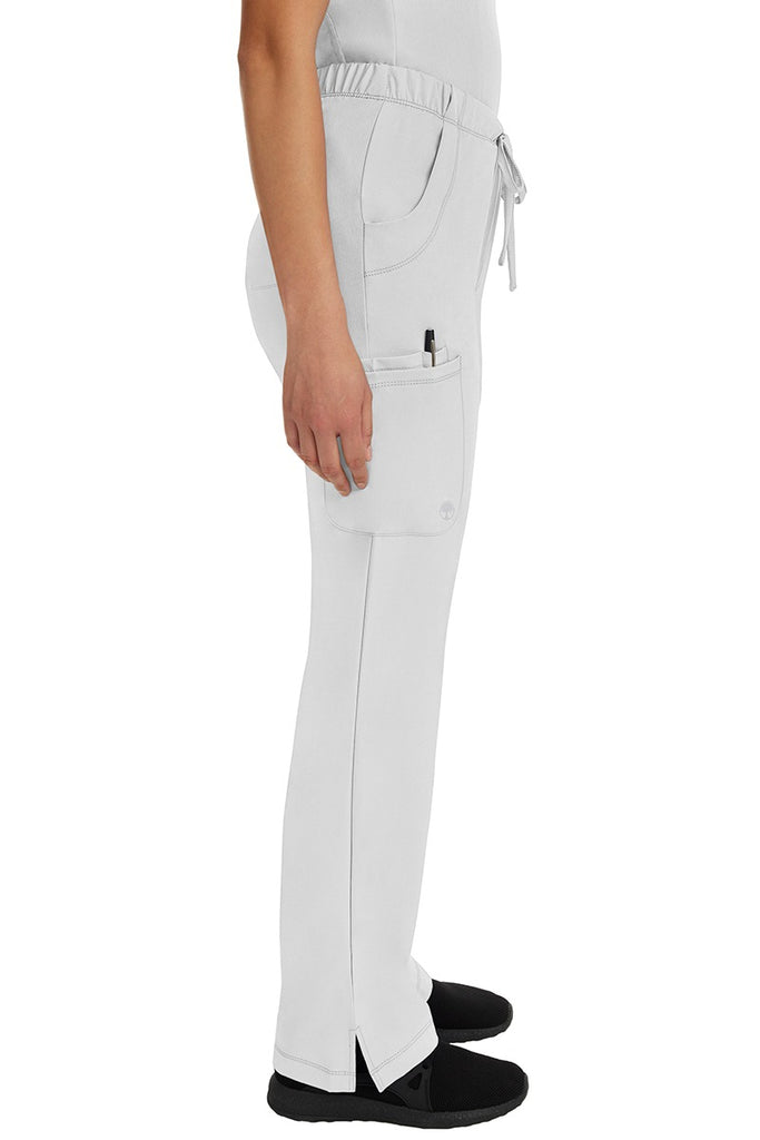 A young woman wearing an HH-Works Women's Rebecca Multi-Pocket Drawstring Pant in White featuring a super comfortable stretch fabric made of 91% polyester & 9% spandex.