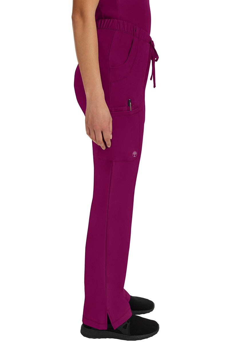 A young woman wearing an HH-Works Women's Rebecca Multi-Pocket Drawstring Pant in Wine featuring a super comfortable stretch fabric made of 91% polyester & 9% spandex.