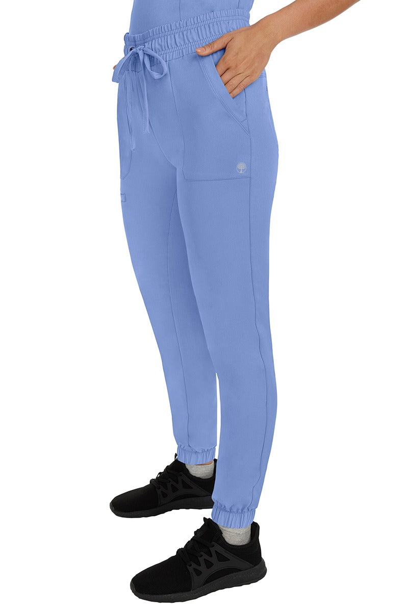 A female healthcare professional wearing a pair of the HH Works Women's Renee Jogger Scrub Pants in Ceil featuring stretchy ankle cuffs at the bottom of each pant leg.