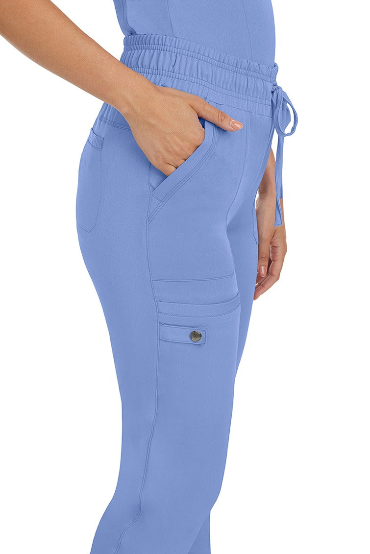 A female nurse wearing a pair of the HH Works Women's Renee Jogger Scrub Pants in Ceil featuring a total of 6 pockets for all of your on the go storage needs.