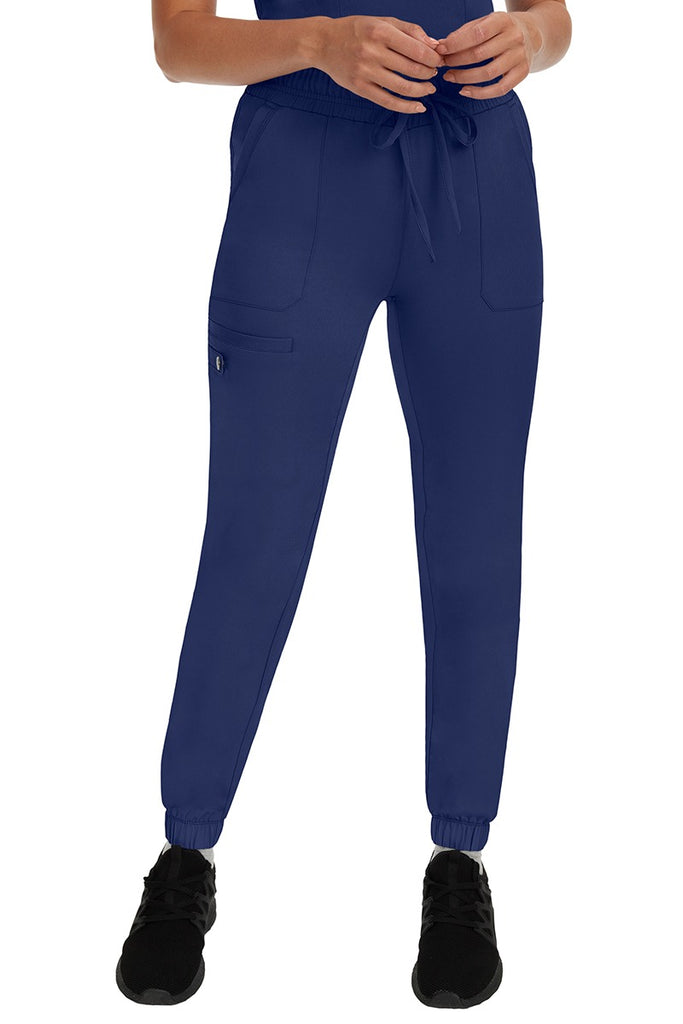A young woman LVN wearing a pair of the HH Works Women's Renee Jogger Scrub Pants in Navy featuring a super comfortable, easy care fabric.