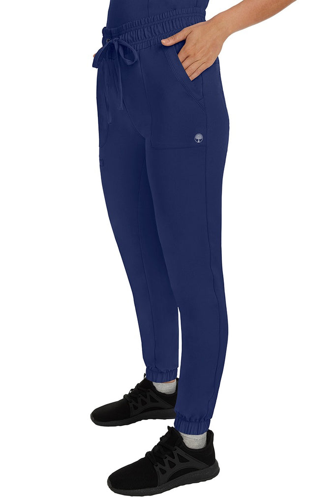 A female healthcare professional wearing a pair of the HH Works Women's Renee Jogger Scrub Pants in Navy featuring stretchy ankle cuffs at the bottom of each pant leg.