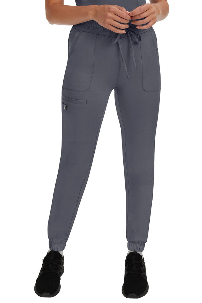 A young woman LVN wearing a pair of the HH Works Women's Renee Jogger Scrub Pants in Pewter featuring a super comfortable, easy care fabric.