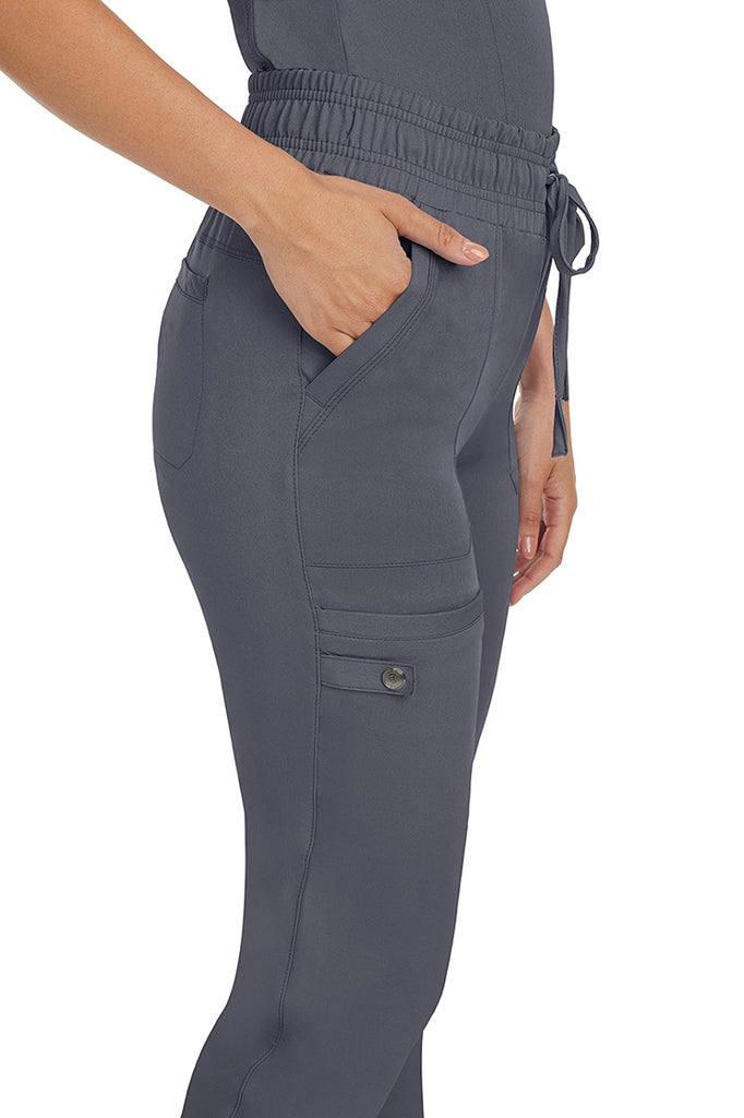 A female nurse wearing a pair of the HH Works Women's Renee Jogger Scrub Pants in Pewter featuring a total of 6 pockets for all of your on the go storage needs.