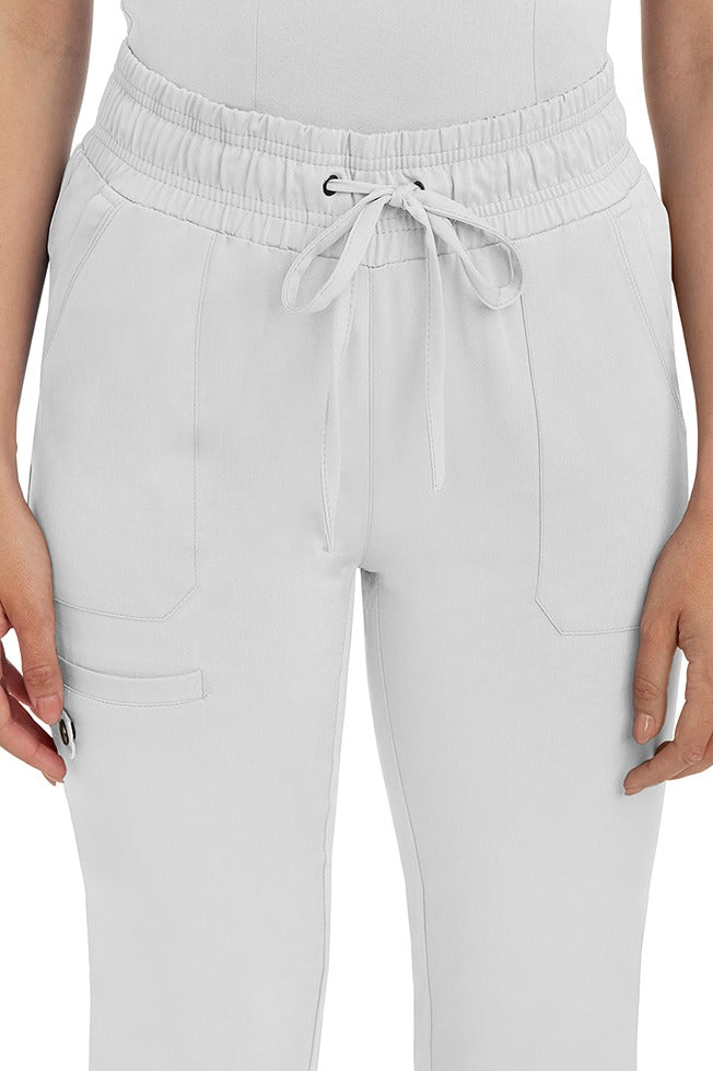 A female nurse wearing a Women's Renee Jogger Scrub Pant from HH Works in White featuring a drawstring tie front.