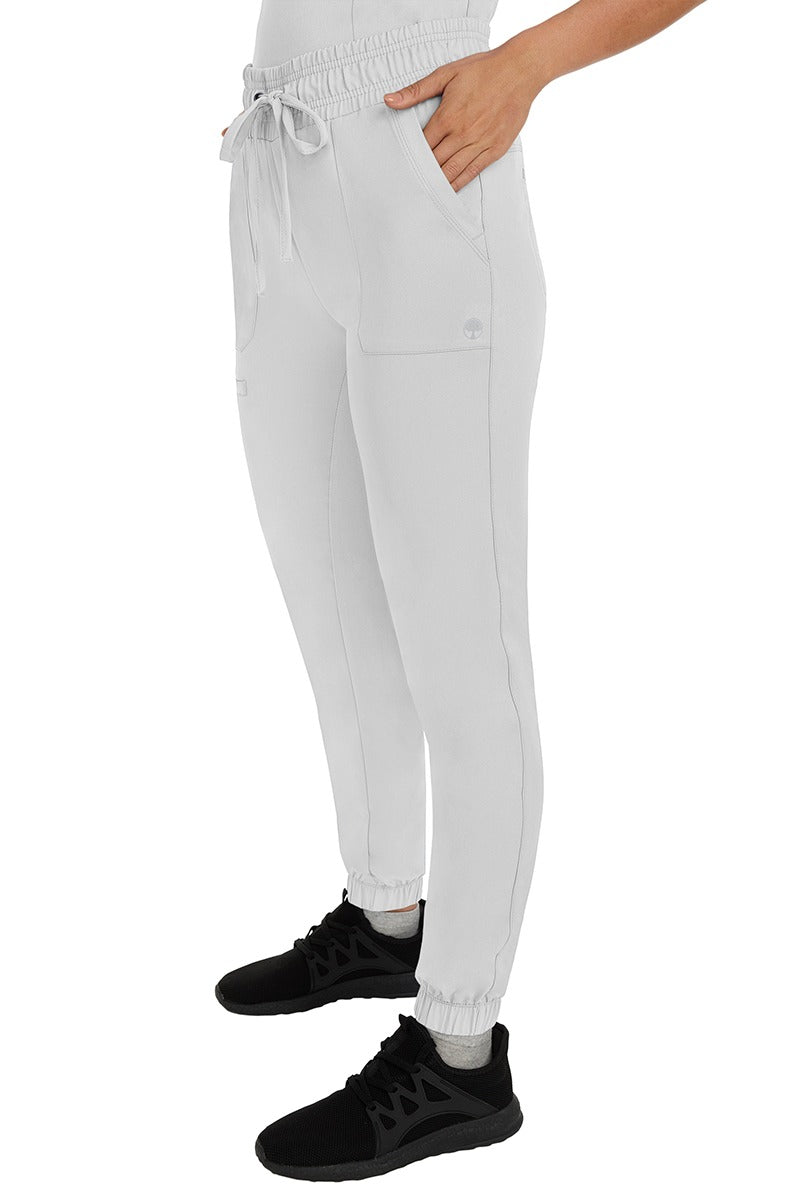 A female healthcare professional wearing a pair of the HH Works Women's Renee Jogger Scrub Pants in White  featuring stretchy ankle cuffs at the bottom of each pant leg.