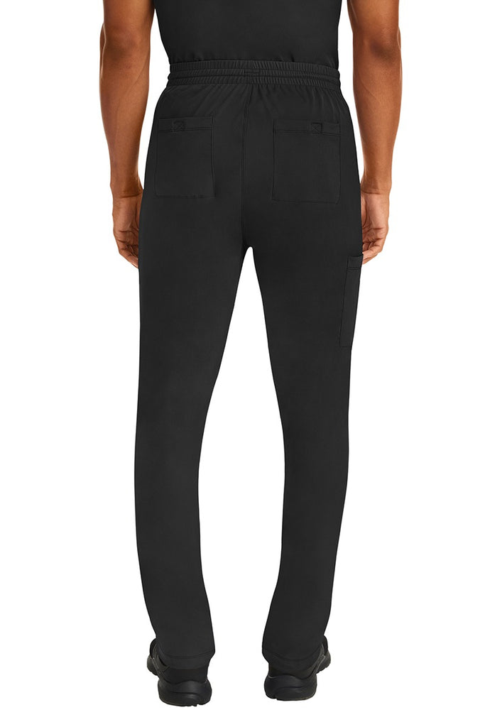 A male Nurse Practitioner wearing an HH-Works Men's Ryan Multi-Pocket Cargo Scrub Pant in Black featuring two back patch pockets.