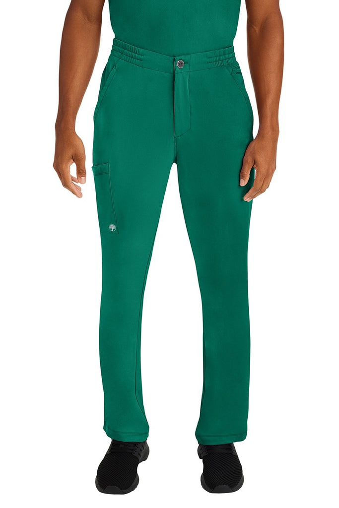 A male LPN wearing a Men's Ryan Multi-Pocket Cargo Scrub Pant from HH Works in Hunter Green size large. featuring a functional zipper front with button closure.