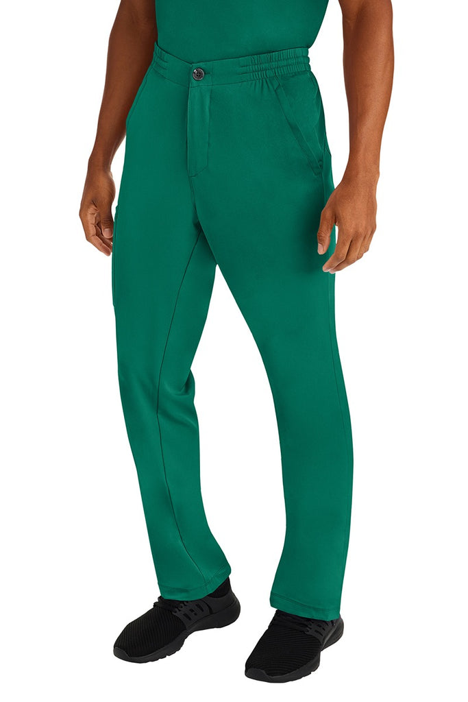 A male clinical nurse specialist wearing an HH-Works Men's Ryan Multi-Pocket Cargo Scrub Pant in Hunter Green featuring a hidden drawstring & elastic waistband.