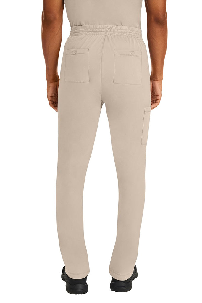 A male Nurse Practitioner wearing an HH-Works Men's Ryan Multi-Pocket Cargo Scrub Pant in Khaki featuring two back patch pockets.
