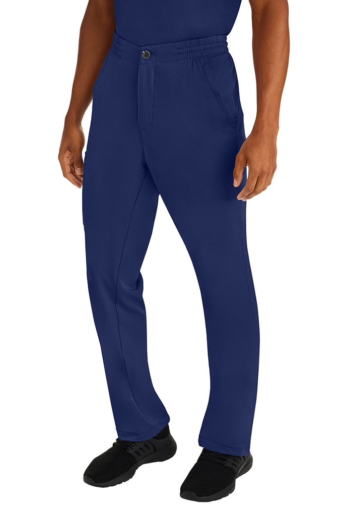 A male clinical nurse specialist wearing an HH-Works Men's Ryan Multi-Pocket Cargo Scrub Pant in Navy  featuring a hidden drawstring & elastic waistband.