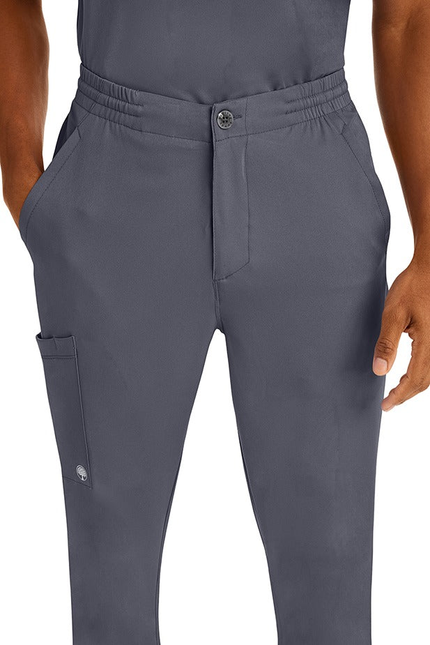 A young man wearing a Men's Ryan Multi-Pocket Cargo Scrub Pant from HH Works in Pewter featuring a super comfortable stretch fabric made of 91% polyester & 9% spandex.