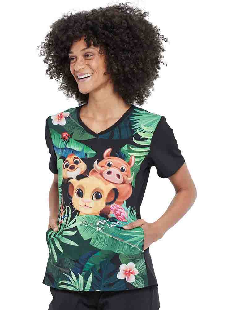 A young female Nurse Practitioner wearing a Cherokee Tooniforms Women's V-neck Print Scrub Top in "Wild Things" size XL featuring 2 side pockets.