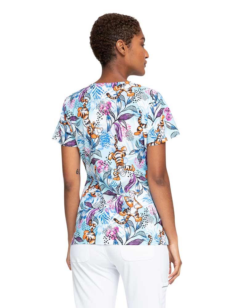 Young woman wearing a Women's V-Neck Print Top from Cherokee Tooniforms in "Tropical Tigger" featuring a total of 4 pockets.